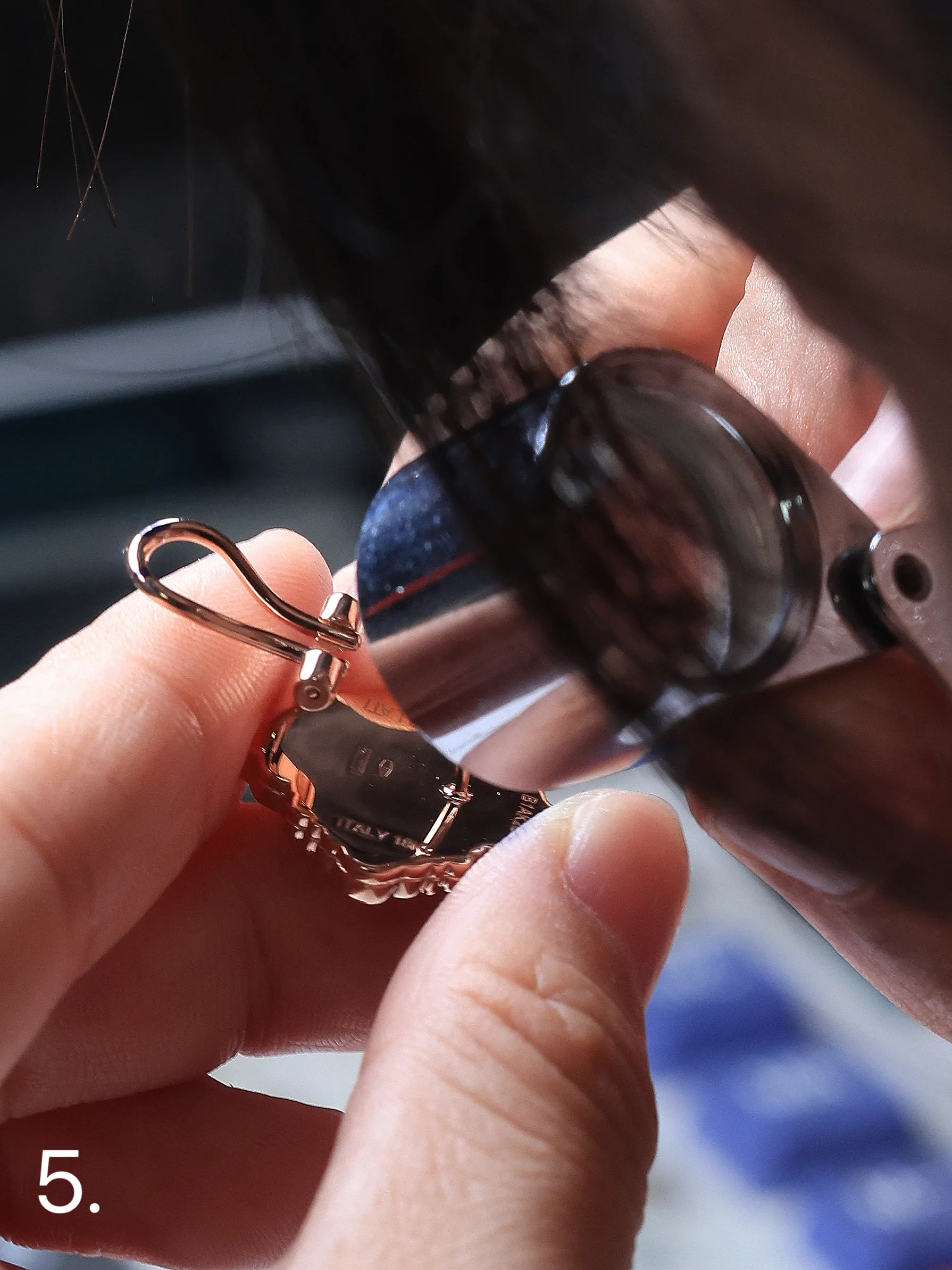 Craftsman polishing a gold ring under a loupe